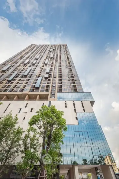 Stunning high-rise building with modern glass facade and lush greenery, perfect for urban living.