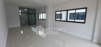 Spacious modern living room with large windows and glossy tiled floors