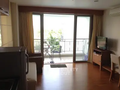 Cozy living room with balcony view, modern furniture, and natural light.