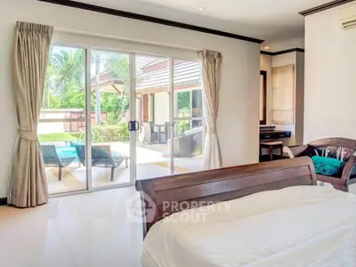 Luxurious bedroom with pool view and elegant wooden furniture in a modern home.