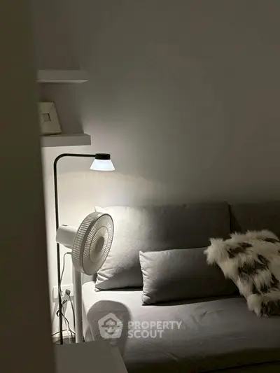 Cozy living room corner with modern gray sofa and stylish lamp