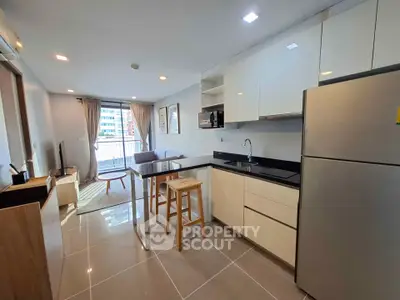 Modern open-layout kitchen and living room with sleek design and natural light.