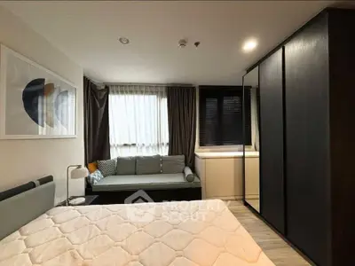 Modern bedroom with cozy seating area and stylish decor