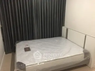 Cozy bedroom with a large bed and dark curtains, perfect for restful nights.