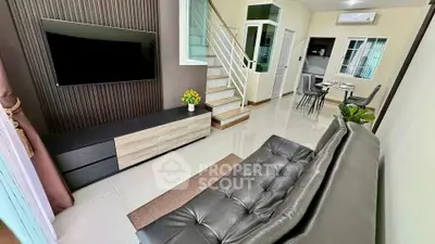 Modern living room with sleek furniture and staircase in a stylish home interior.