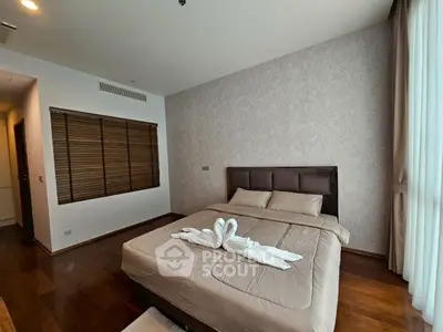 Cozy bedroom with elegant decor and natural light, featuring a stylish bed and wooden flooring.