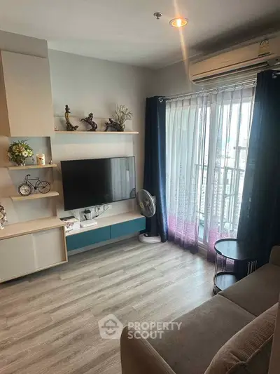 Modern living room with balcony view, featuring stylish decor and natural light.