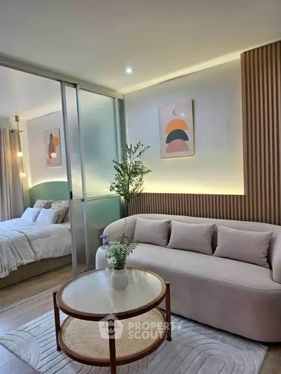 Modern living room with cozy sofa and stylish decor adjacent to a serene bedroom.
