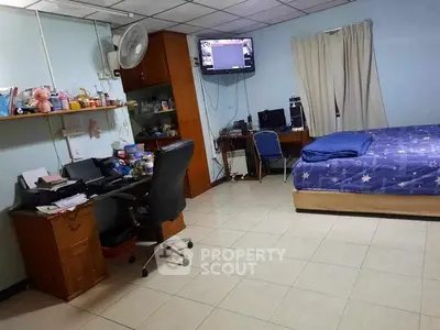 Spacious bedroom with study area, featuring tiled floors and cozy decor.
