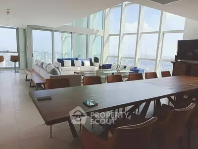 Luxurious penthouse living room with panoramic city views and modern furnishings.