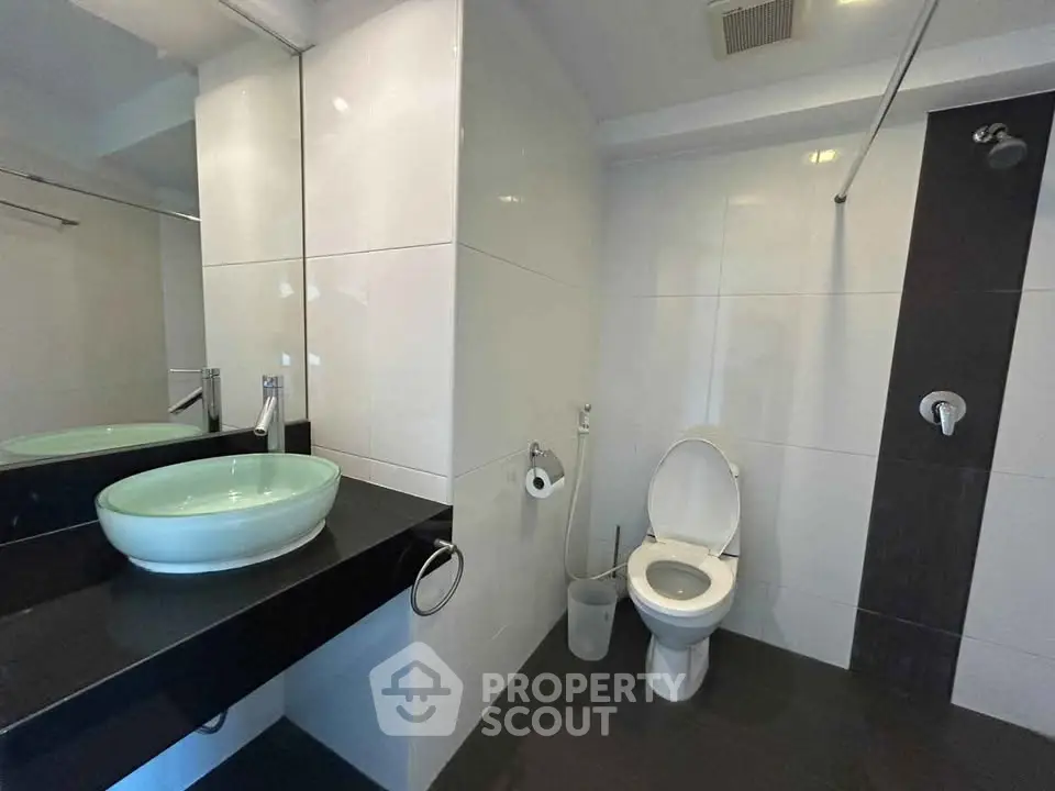 Modern bathroom with sleek design featuring a vessel sink and contemporary fixtures.