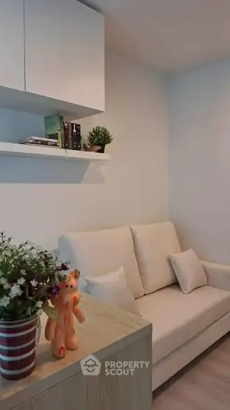 Cozy living room with white sofa and decorative shelves in modern apartment.