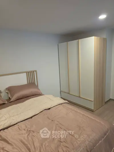 Cozy bedroom with modern wardrobe and elegant bedding in a stylish apartment.
