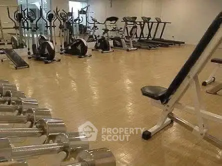 Spacious gym with modern fitness equipment in a residential building.