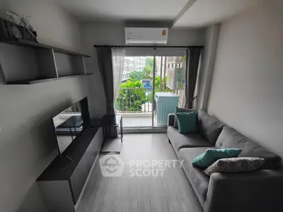 Modern living room with balcony view, sleek furniture, and air conditioning.