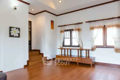 Spacious living room with wooden floors and elegant curtains