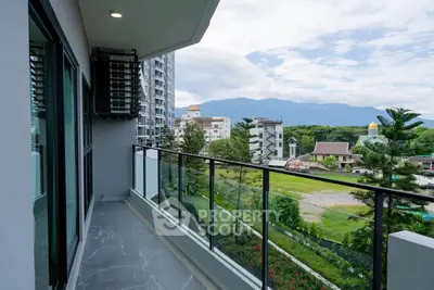 Spacious balcony with stunning mountain and city views in modern apartment.