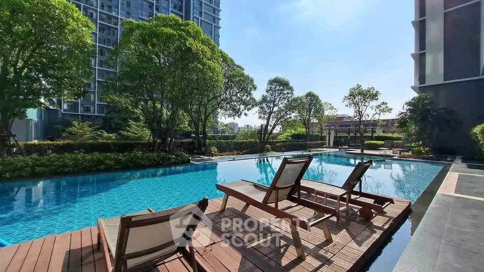 Luxurious poolside view with modern high-rise buildings and lush greenery, perfect for relaxation and leisure.