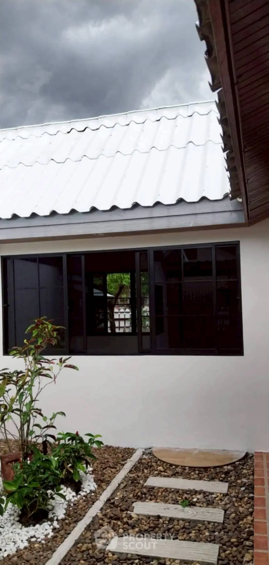 Charming exterior view of modern home with white roof and garden pathway.