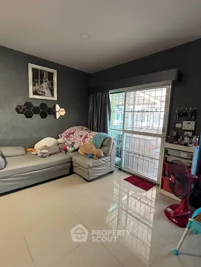 Cozy living room with modern decor and sliding glass door access to balcony.