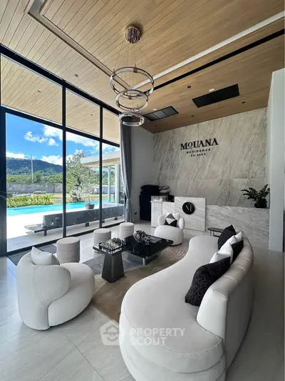 Luxurious living room with modern furniture and stunning pool view at Mouana Residence.