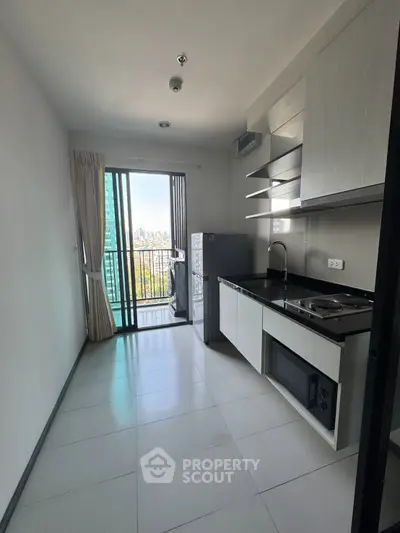 Modern kitchen with balcony view in high-rise apartment