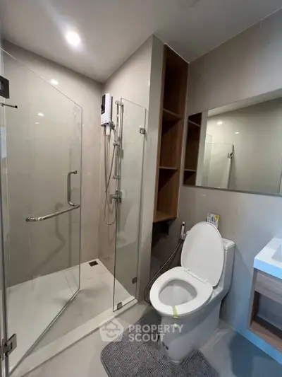 Modern bathroom with glass shower and sleek fixtures in a contemporary apartment.