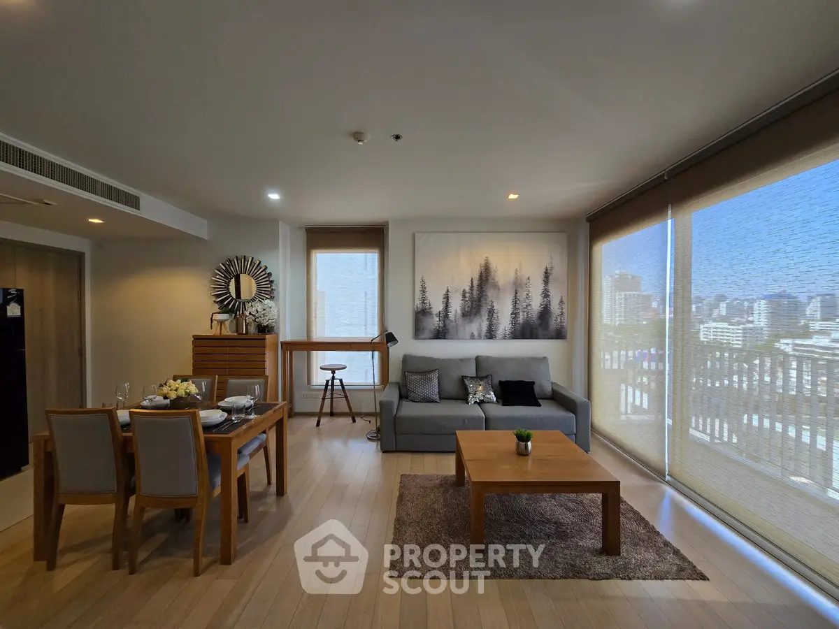 Spacious modern living room with city view, elegant decor, and abundant natural light.