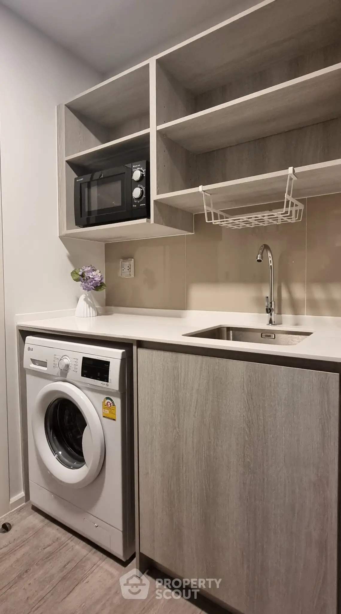 Modern kitchen with washing machine and microwave in sleek cabinetry