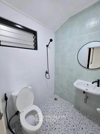 Modern bathroom with sleek fixtures and terrazzo flooring, featuring a round mirror and minimalist design.