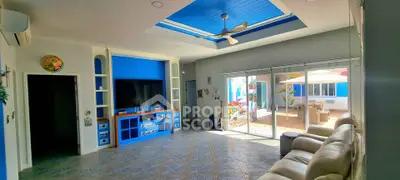 Spacious living room with modern decor and large windows opening to a sunny patio.
