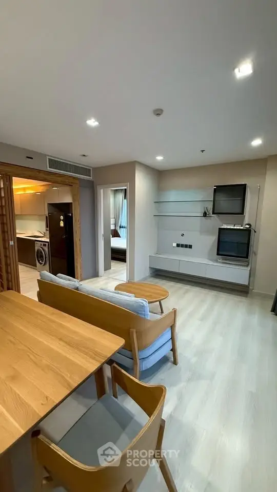 Modern open-plan living room with wooden furniture and sleek kitchen design