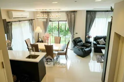 Luxurious open-plan living and dining area with elegant furnishings and garden view.