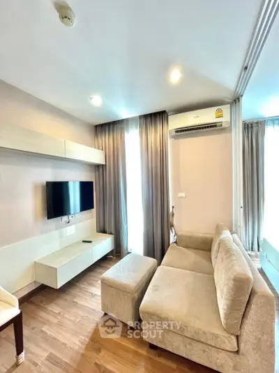 Modern living room with sleek furniture and wall-mounted TV in cozy apartment