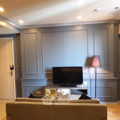 Stylish living room with modern decor and flat-screen TV, perfect for relaxation.