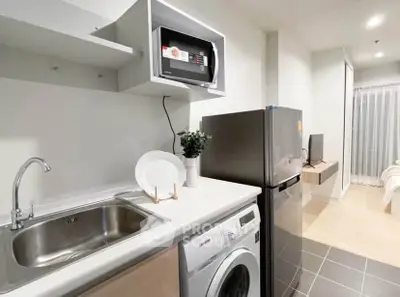 Modern kitchen with sleek appliances and open layout in stylish apartment.