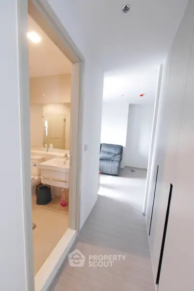 Modern apartment hallway with view into a bathroom and living area.