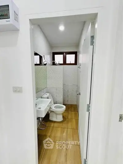 Modern bathroom with wooden flooring and white fixtures