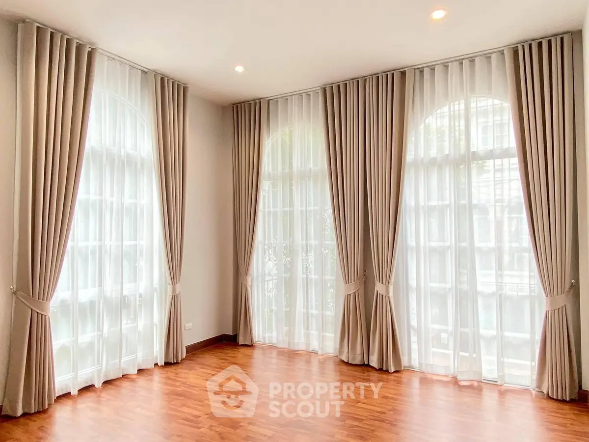 Spacious corner unit with elegant floor-to-ceiling windows and luxurious curtains.