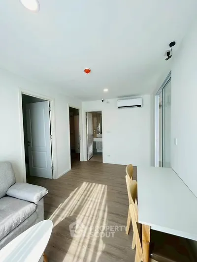 Bright modern living room with sleek furniture and large windows in a contemporary apartment.