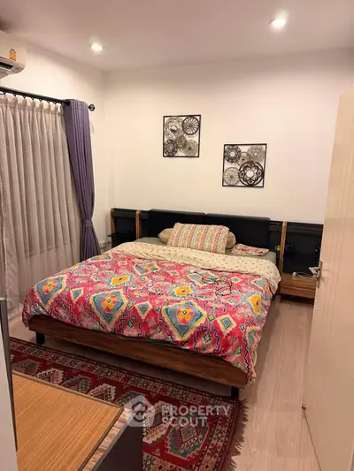 Cozy bedroom with colorful bedding and modern decor in a stylish apartment.