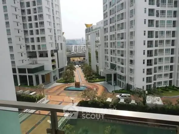 Modern apartment complex with spacious courtyard and sleek architecture.