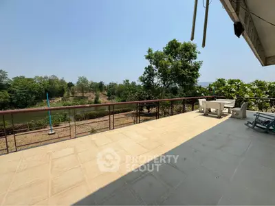 Spacious balcony with scenic river view and outdoor seating, perfect for relaxation and entertaining.