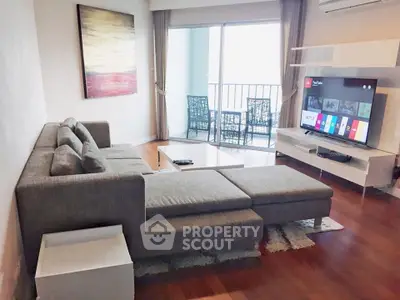 Modern living room with stylish furniture and balcony view, perfect for relaxation and entertainment.