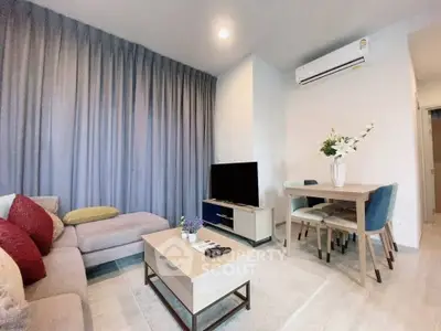 Modern living room with cozy sofa and dining area, featuring air conditioning and stylish decor.