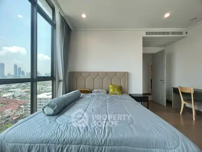 Spacious bedroom with city view and modern furnishings in a high-rise apartment.