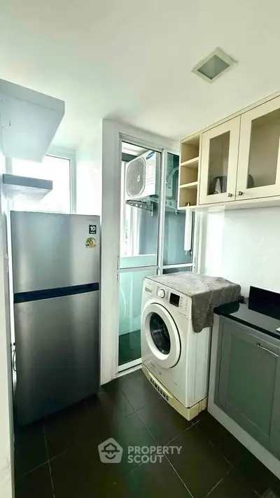Modern kitchen with washing machine and fridge in compact layout