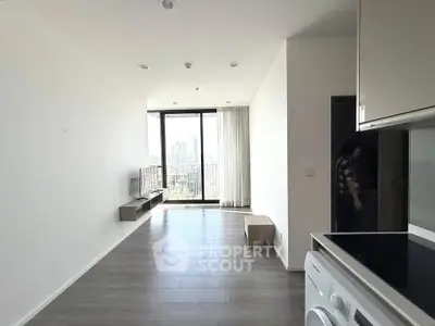 Modern living room with large windows and city view, featuring sleek flooring and minimalist design.