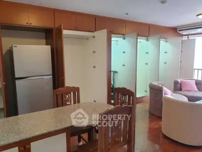 Spacious living room with open kitchen and ample storage in modern apartment.