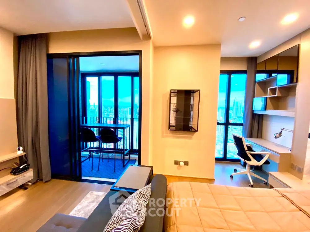 Modern apartment interior with balcony and city view, featuring stylish furniture and workspace.